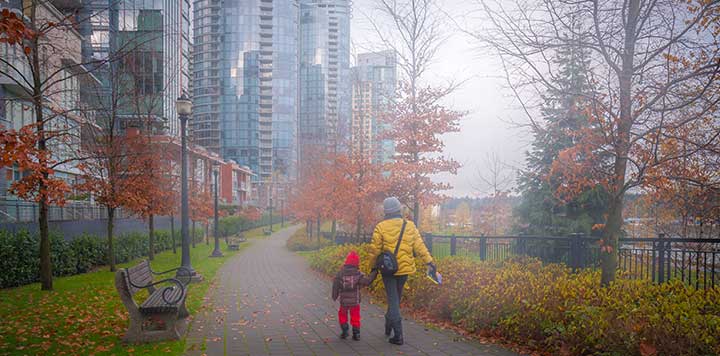 Woman and child holding hands walking downtown Woman and child holding hands walking downtown
