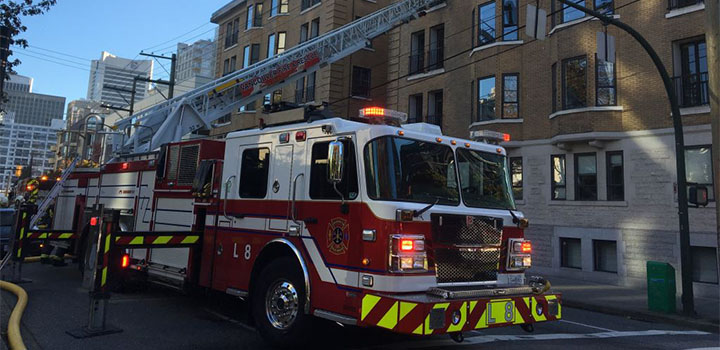 A firetruck with its ladder extended in front of a building A firetruck with its ladder extended in front of a building