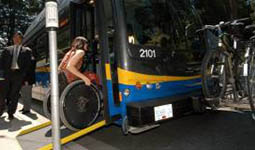 Woman using a wheelchair boarding a bus using a ramp Woman using a wheelchair boarding a bus using a ramp