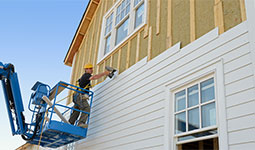 Construction crew member working on outside of a new home. Construction crew member working on outside of a new home.