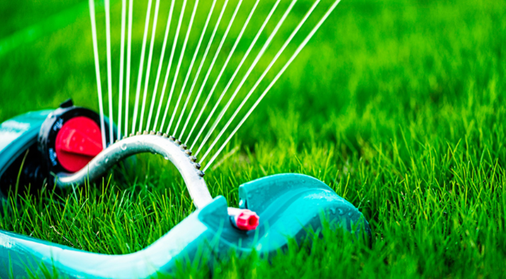 Lawn sprinkler with water spraying onto the grass